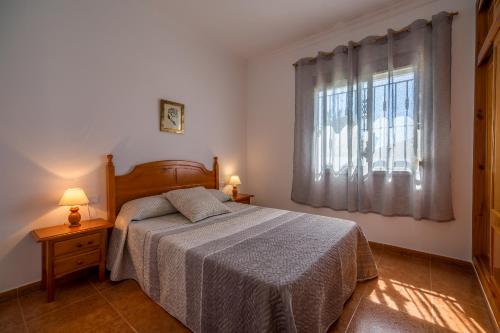 um quarto com uma cama e uma janela em Chalet Pedro II em Conil de la Frontera