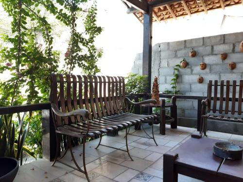 a patio with two wooden benches and a table at Pousada Casa da Gente in Caruaru