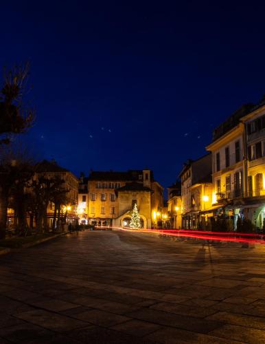 an empty street at night with buildings and lights at Le3stanze in Borgomanero