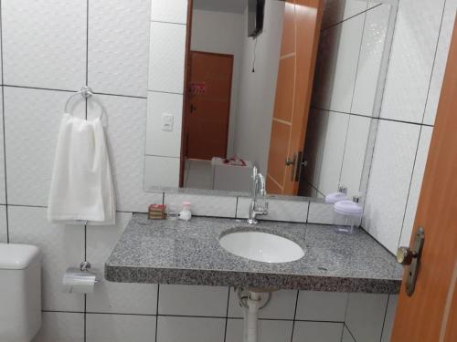 uma casa de banho com um lavatório e um espelho em Pousada Chácara do Coqueiro em Barreirinhas