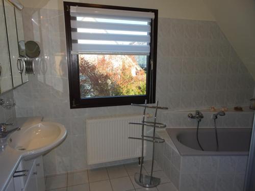 a bathroom with a sink and a tub and a window at Helle moderne 52 qm Wohnung mit Balkon in Chemnitz