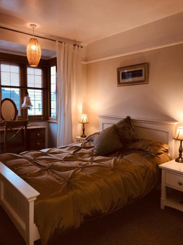 a bedroom with a bed and two tables with lamps at Serendipity in Broadstairs