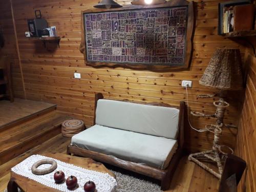 a room with a chair and a table and a lamp at צימר בגליל אביב בבקתה in Galilee