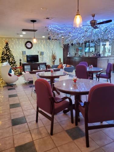 a restaurant with tables and chairs and a christmas tree at Houston Inn and Suites in Houston