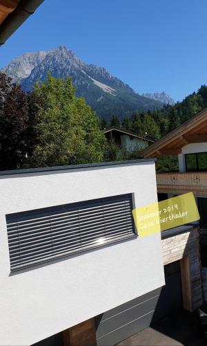 a white building with a mountain in the background at Casa Vierthaler in Scheffau am Wilden Kaiser