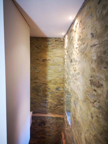 a room with a stone wall and a hallway at Casa Kika e Noelle in Castanheira de Pêra