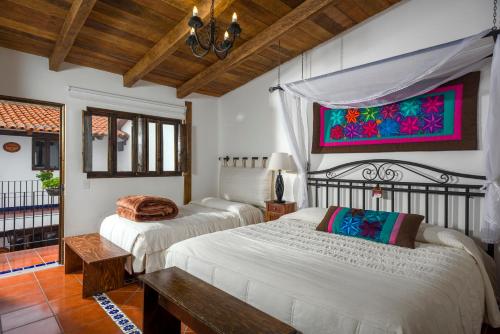 a bedroom with two beds and a painting on the wall at Hotel Tapalpa de Mis Amores in Tapalpa