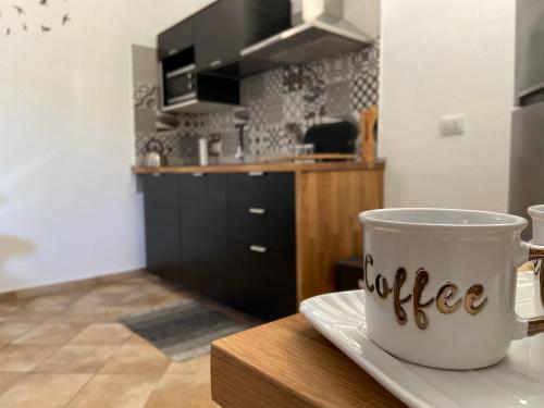 a coffee cup on a plate on a table in a kitchen at Casa Calles in Siracusa