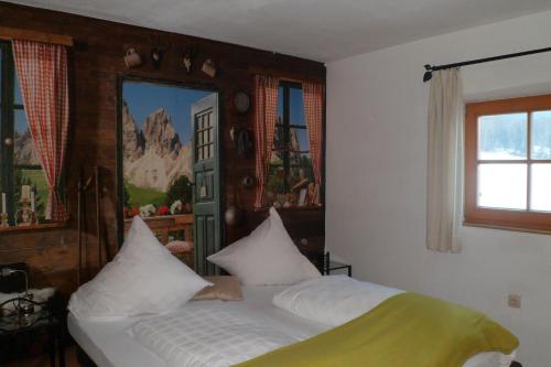 a bedroom with a bed with white sheets and a window at Berggasthaus Kraxenberger in Brannenburg