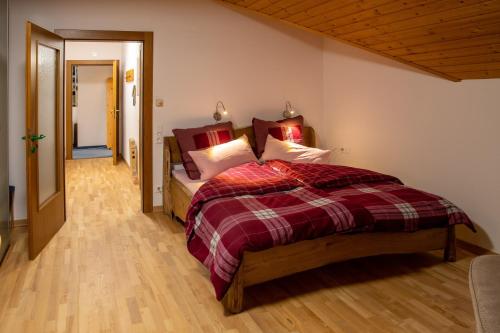 a bedroom with a bed with a red plaid blanket at Haus am Römerbad in Bad Kleinkirchheim