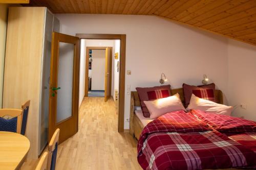a bedroom with a bed with red and white pillows at Haus am Römerbad in Bad Kleinkirchheim