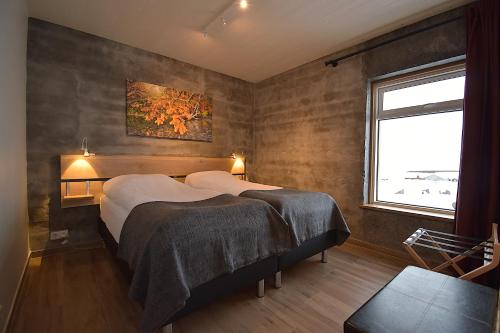 a bedroom with two beds and a window at The Potato Storage in Svínafell