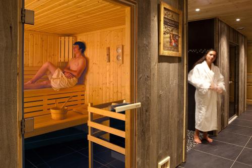 a man and a woman standing in a sauna at Hotel le Petit Dru in Morzine