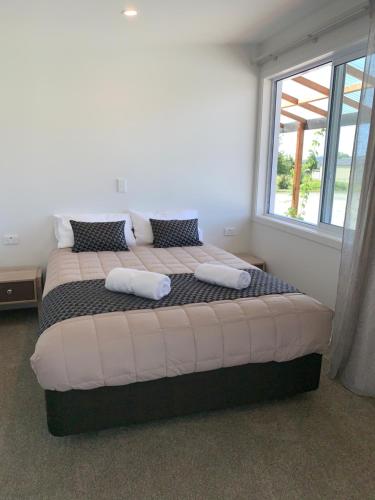 a large bed in a room with a window at Woodstock Hotel in Hokitika