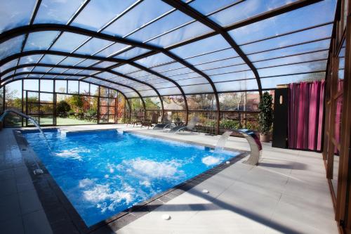 an indoor swimming pool with a glass roof at Luces del Poniente in Cercedilla