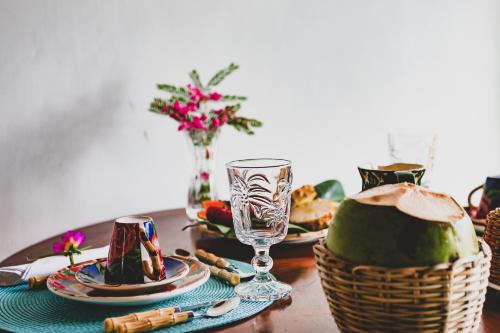 a table with a plate of food and a wine glass at Anbê Hospedaria in Arraial d'Ajuda