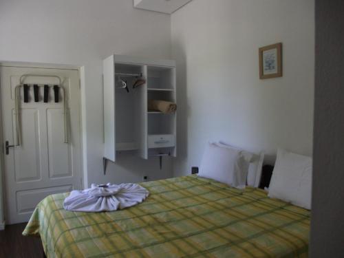 a bedroom with a bed with a yellow blanket at Pousada Max Pomerode in Pomerode