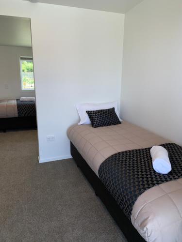 a bedroom with a bed in a room with a mirror at Woodstock Hotel in Hokitika