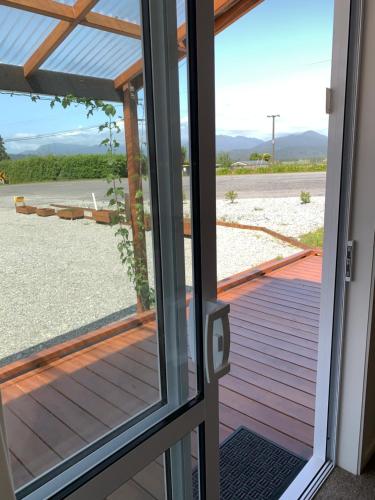 a door to a porch with a view of the beach at Woodstock Hotel in Hokitika