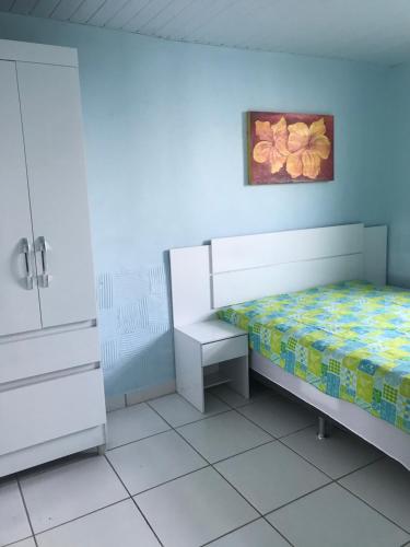 1 dormitorio con 1 cama y una pintura en la pared en Casa praia frente ao mar en Florianópolis