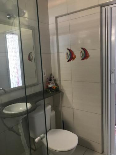 uma casa de banho com um WC, um lavatório e um espelho. em Casa praia frente ao mar em Florianópolis