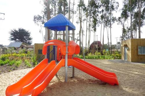 a playground with a red slide in a park at Hermoso y nuevo departamento en Algarrobo Norte in Algarrobo