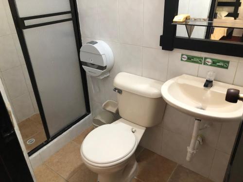 a bathroom with a toilet and a sink at Hotel Campestre Casona del Camino Real in San Gil