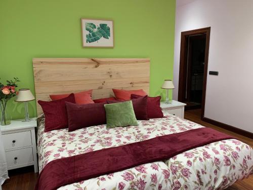 een slaapkamer met een groot bed met rode en groene muren bij En pleno centro de Bilbao y muy cerca del GUGGENHEIM in Bilbao