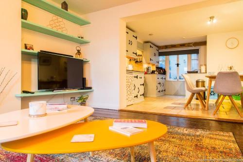 a living room with a table and a tv at Seafront Apartment with Garden in Brighton & Hove