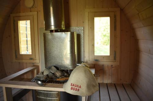 a stove in a wooden cabin with two windows at Sämi Siil in Sämi
