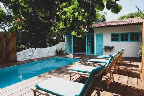 a patio with chairs and a swimming pool at Anbê Hospedaria in Arraial d'Ajuda