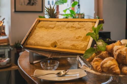 a beehive on a table with a plate of bread at Ventus Rosa Boutique Aparthotel in Kraków