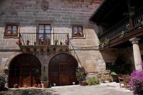 a building with two doors and a balcony with flowers at Casa Velarde in Torrelavega