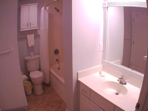 een badkamer met een wastafel, een toilet en een spiegel bij Ocean Walk Resort 1305 in Daytona Beach