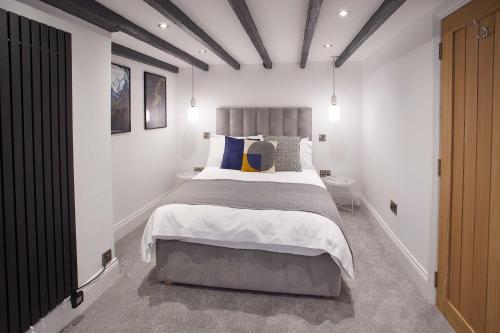 um quarto com uma cama grande num quarto branco em Host & Stay - Burns Yard Apartment em Whitby