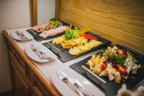 a table with three plates of food on it at Ventus Rosa Boutique Aparthotel in Kraków