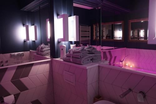 a bathroom with pink lighting and sinks and mirrors at Apartament Augustów SWAN in Augustów