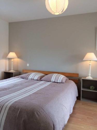 une chambre avec un grand lit avec deux lampes dans l'établissement Maison Béniguet au Pays des Abers, à Plouguerneau