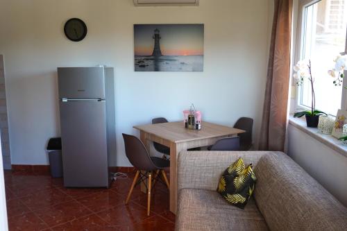 - un salon avec une table et un réfrigérateur dans l'établissement Apartment Munida, à Medulin