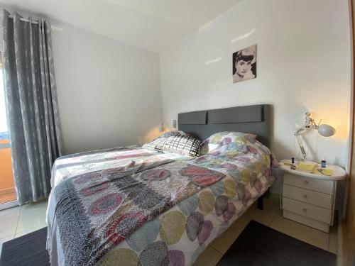 a small bedroom with a bed and a night stand at Cozy rooms in terraced house in Fuengirola