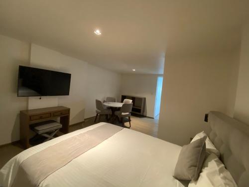 a bedroom with a bed and a desk and a television at Casa Londres in Mexico City