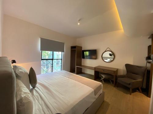 メキシコシティにあるCasa Londresのベッドルーム1室(ベッド1台、椅子、鏡付)