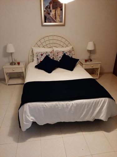 a bedroom with a large white bed with pillows at family apartment near of beach in Benidorm