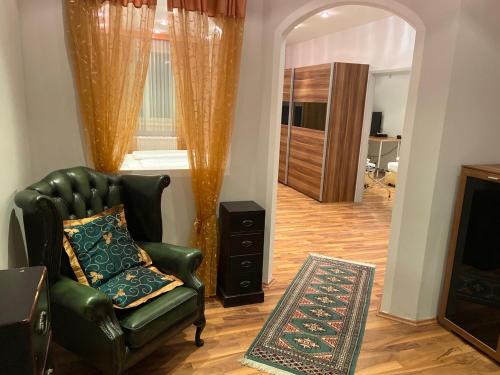 - un salon avec un fauteuil en cuir vert et une cheminée dans l'établissement Ferienappartement Auerhahn, à Vöcklabruck
