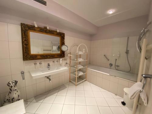 a bathroom with a sink and a tub and a mirror at Ferienappartement Auerhahn in Vöcklabruck