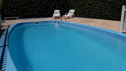 two chairs sitting next to a blue swimming pool at POUSADA LOS AMIGOS CAMPECHE in Florianópolis
