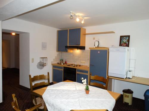 a small kitchen with a table and a refrigerator at Appartement Haus Seerose in Reith im Alpbachtal