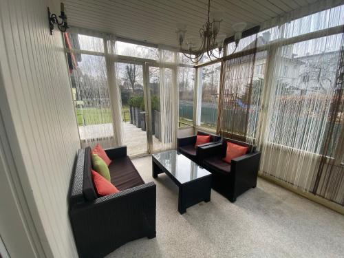 a screened in porch with two chairs and a table at Ferienappartement Vöcklabruck in Vöcklabruck