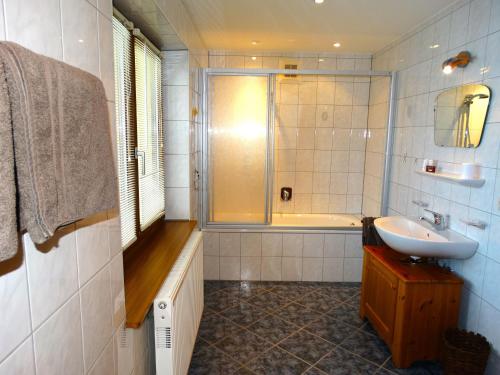 a bathroom with a tub and a sink and a shower at Appartement Haus Seerose in Reith im Alpbachtal