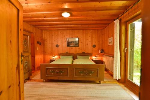 um quarto com uma cama num quarto de madeira em Ferienwohnung Waldheimat 2 em Bayerisch Eisenstein